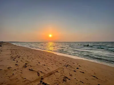 a sunset on the beach with footprints in the sand at The Smart Concierge - La Rive Port De Lamer in Dubai