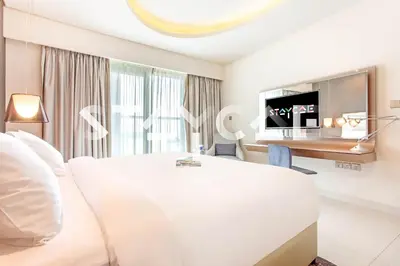 a hotel room with a bed and a desk at Staycae Holiday Homes - Damac Towers By Paramount in Dubai