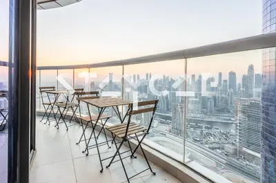 a row of tables and chairs on a balcony overlooking a city at Staycae Holiday Homes - Damac Towers By Paramount in Dubai