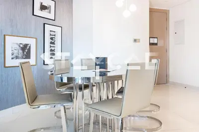 a dining room with a glass table and chairs at Staycae Holiday Homes - Damac Towers By Paramount in Dubai