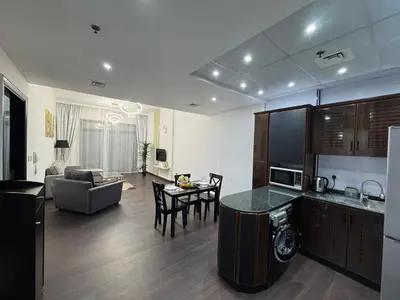 a kitchen and living room with a couch and a table at Stay in the heart of Sport City in LUX 1BDR with sky view 11 in Dubai