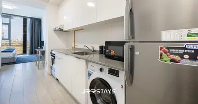 a kitchen with a washer and dryer in a room at Sophisticated Studio JVC - Breathtaking City View in Dubai