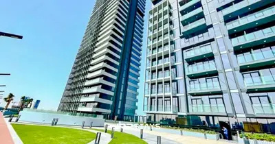 a tall building with a park in front of it at Sophisticated Studio JVC - Breathtaking City View in Dubai