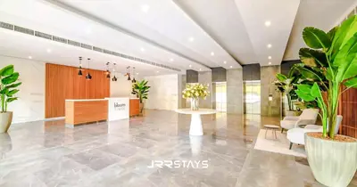 a lobby with potted plants and a table at Sophisticated Studio JVC - Breathtaking City View in Dubai