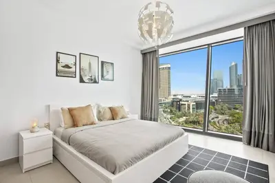 a white bedroom with a bed and a large window at Khalifa Views & Direct Mall Access in Burj Vista in Dubai