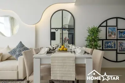 a dining room with a table and a couch at Marina & Beach Views, Pool, Art Haven! Near Cafes in Dubai