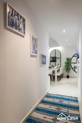a hallway with white walls and a blue rug at Marina & Beach Views, Pool, Art Haven! Near Cafes in Dubai