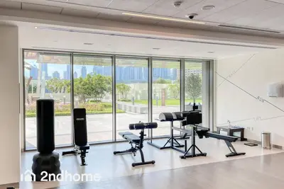 a gym with cardio equipment and a large window at 2ndHome - Downtown Views 1 - Downtown Dubai in Dubai