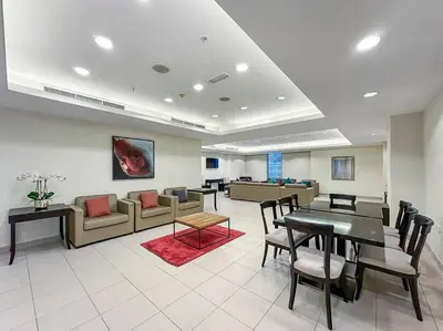 a waiting room with a table and chairs and a couch at FIRST CLASS 2BR Incredible Burj Khalifa View in Dubai