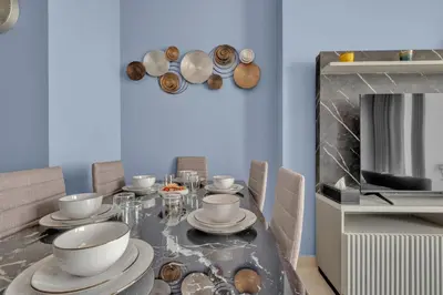 a dining room with a table with plates and bowls at Stylish 2BR for 6 with King Beds, Pool, Gym in JVC in Dubai