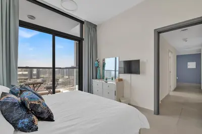 a bedroom with a large bed with a large window at Stylish 2BR for 6 with King Beds, Pool, Gym in JVC in Dubai