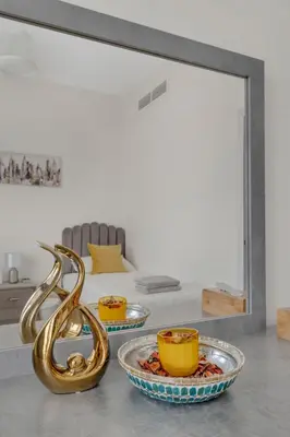 a mirror on a counter with two bowls and a plate at Stylish 2BR for 6 with King Beds, Pool, Gym in JVC in Dubai