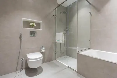 a bathroom with a shower and a toilet and a sink at Serene and sophisticated Lagoon Living - Suiteable in Dubai