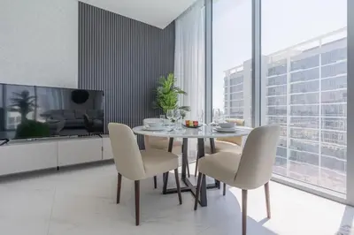 a dining room with a table and chairs and a tv at Serene and sophisticated Lagoon Living - Suiteable in Dubai