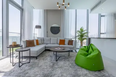 a living room with a couch and tables and windows at Serene and sophisticated Lagoon Living - Suiteable in Dubai