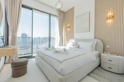 a bedroom with a large white bed and a large window at Every Sunset is a Masterpiece in Catch Residence in Dubai