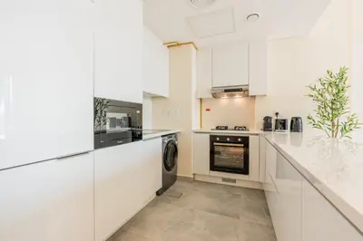a kitchen with white cabinets and a dishwasher at Every Sunset is a Masterpiece in Catch Residence in Dubai