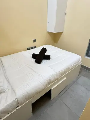 a bed in a room with a black object on it at Hostel with Private Room near Downtown Business Bay in Dubai