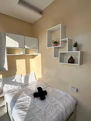 a black hat sitting on a bed in a bedroom at Hostel with Private Room near Downtown Business Bay in Dubai