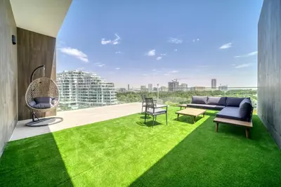 a living room with green grass and a couch at Stella Stays Al-Barari in Dubai