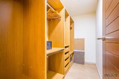 a walk in closet with wooden cabinets and a door at Beautiful 2BR apartment in Al Sahab 2, Dubai Marina by Deluxe Holiday Homes in Dubai