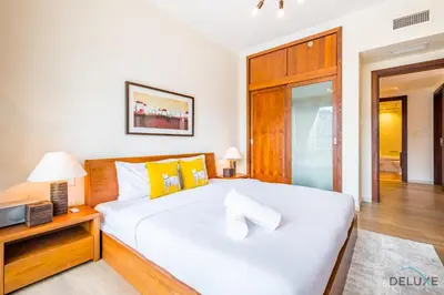 a bedroom with a large white bed with yellow pillows at Beautiful 2BR apartment in Al Sahab 2, Dubai Marina by Deluxe Holiday Homes in Dubai
