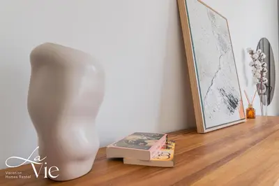 a white vase sitting on a floor next to a stack of books at La Vie, JBR in Dubai