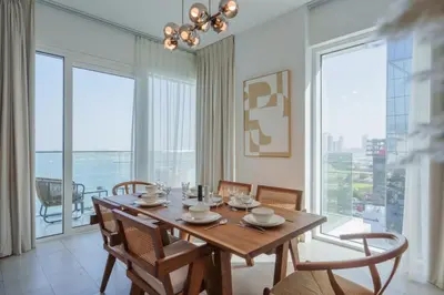 a dining room with a table and chairs and large windows at La Vie, JBR in Dubai