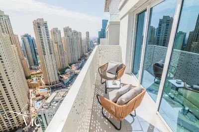 a balcony with chairs and a view of a city at La Vie, JBR in Dubai