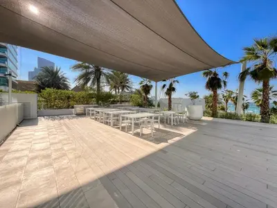 a patio with tables and chairs under a large umbrella at La Vie, JBR in Dubai