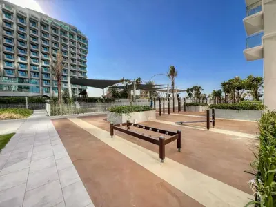 a park with benches in front of a building at La Vie, JBR in Dubai