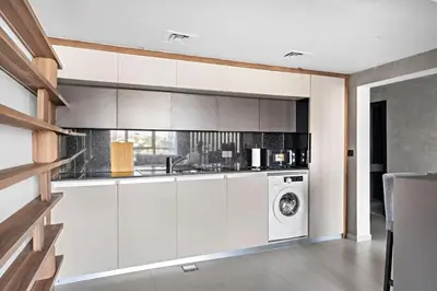 a kitchen with white cabinets and a washer and dryer at Amazing 1br located in the heart of Dubai,JLT in Dubai