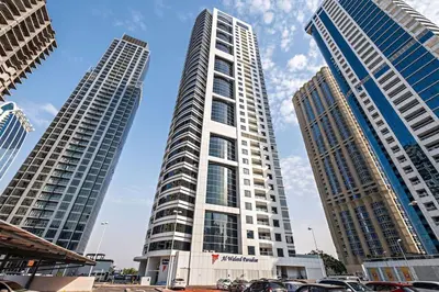 two tall buildings with cars parked in front of them at Amazing 1br located in the heart of Dubai,JLT in Dubai