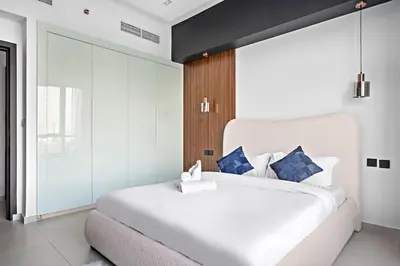 a bedroom with a large white bed with blue pillows at Amazing 1br located in the heart of Dubai,JLT in Dubai