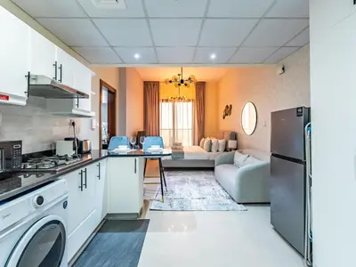 a kitchen and living room with a couch at Elite Vista Studio Elite 10 Sports Residences in Dubai