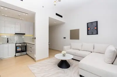 a white living room with a white couch and a table at CitiHome - 1BR Freshly Styled and Comfortable in JVC in Dubai
