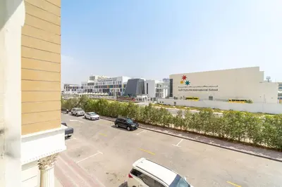 a parking lot with cars parked in front of a building at Studio Apartment in Resotz Residence Arjan - Close to Miracle Garden in Dubai
