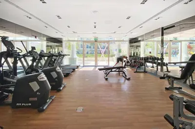 a gym with treadmills and elliptical machines at Studio Apartment in Resotz Residence Arjan - Close to Miracle Garden in Dubai