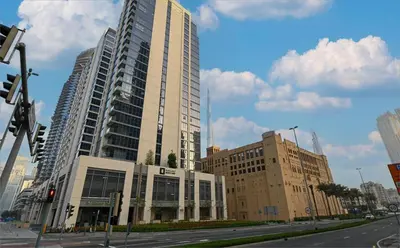 a tall building on the corner of a city street at Apartment with Burj Khalifa View I Bellevue Tower in Dubai