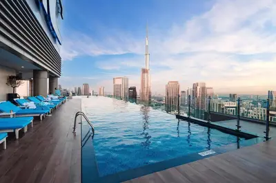 a pool on the roof of a building with a view at Paramount Downtown Burj Khalifa View with 64th floor Infinity pool in Dubai