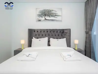 a bedroom with a large white bed with two pillows at Paramount Downtown Burj Khalifa View with 64th floor Infinity pool in Dubai