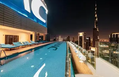 a swimming pool on top of a building with a city skyline at Paramount Downtown Burj Khalifa View with 64th floor Infinity pool in Dubai
