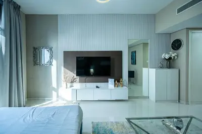 a living room with a tv on a wall at Escape24 Studio at Loreto with Community View in Dubai