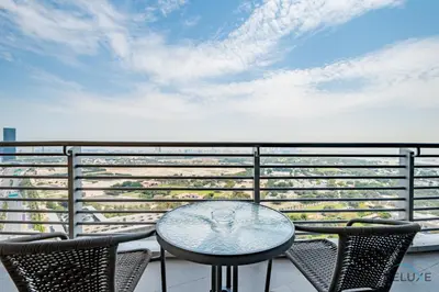 a table and chairs on a balcony with a view of the beach at Jubilant Studio at Sky Gardens, DIFC by Deluxe Holiday Homes in Dubai