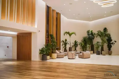 a lobby with palm trees and couches at Jubilant Studio at Sky Gardens, DIFC by Deluxe Holiday Homes in Dubai