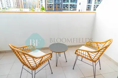 two chairs and a table on a balcony at Bloomfields Cozy Stu Azizi Riviera Meydan in Dubai