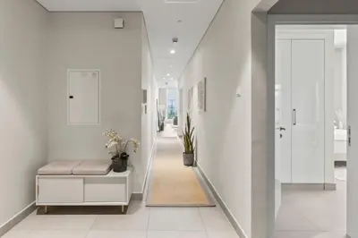 a hallway with white walls and a staircase with a bench at GuestReady - Luxury haven at Marina Arcade in Dubai