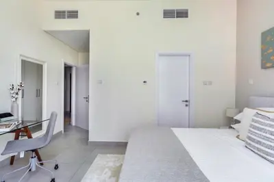 a white bedroom with a desk and a bed at GuestReady - Luxury haven at Marina Arcade in Dubai