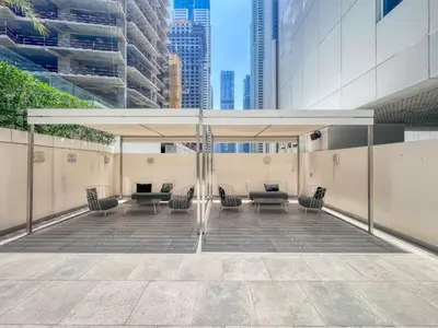 acovered patio with chairs and tables in a building at GuestReady - Luxury haven at Marina Arcade in Dubai