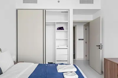 a bedroom with a bed and a closet with towels at Family Friendly 2BDR With Sea & City View in Dubai